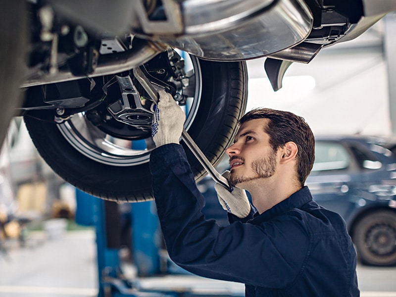 Auto car repair service center. Mechanic examining car suspension