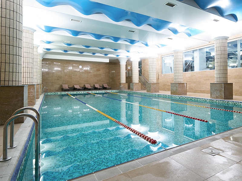 Indoor public swimming pool interior in fitness gym club. healthy concept